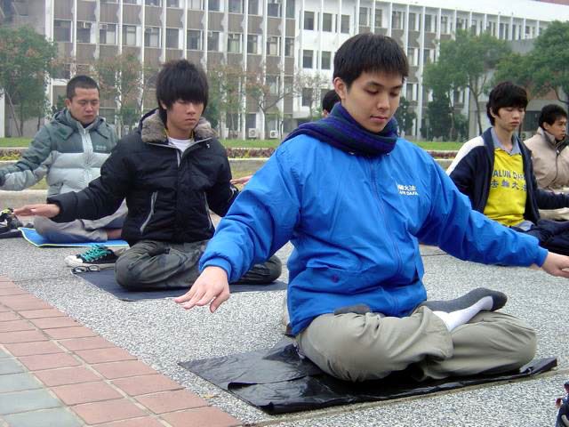 '圖1：丁楷庭（前一）參加當地集體煉功活動，煉第五套功法（神通加持法）'