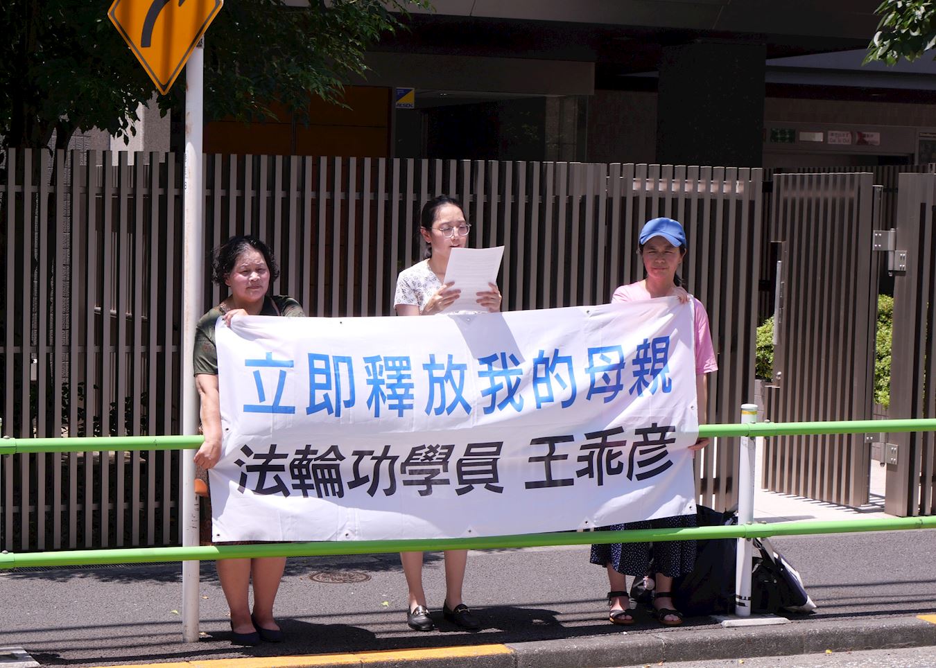 '图3:张一文(中)在中共大使馆前宣读抗议信。'