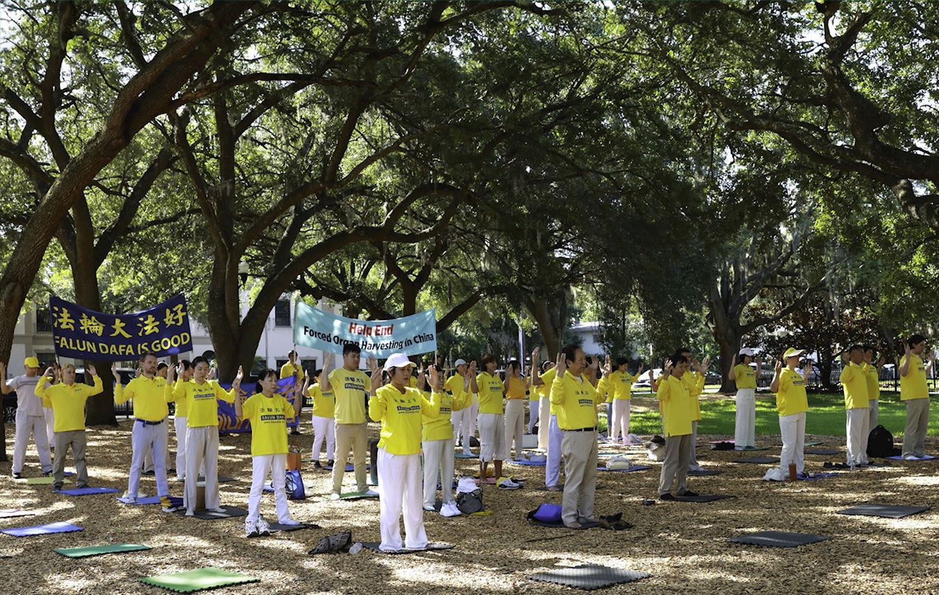 '图1:二零二四年七月二十日,美国佛罗里达州部份法轮功学员在奥兰多市中心的伊奥拉湖(Lake Eola)畔举办集体炼功向民众讲真相活动。'