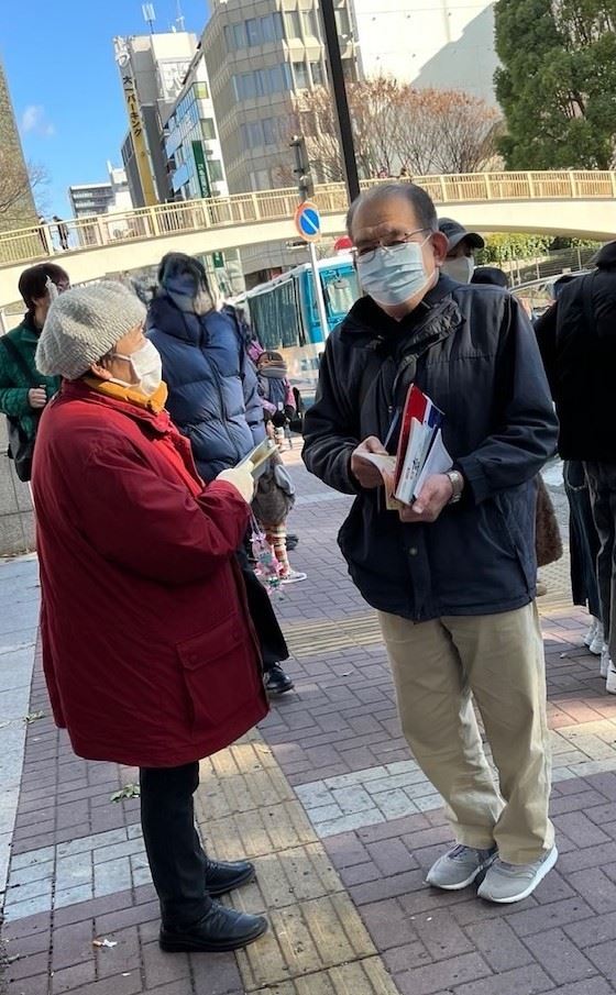 '图4:二零二五年一月十一日,法轮功学员在向行人(右)讲真相时的情景'