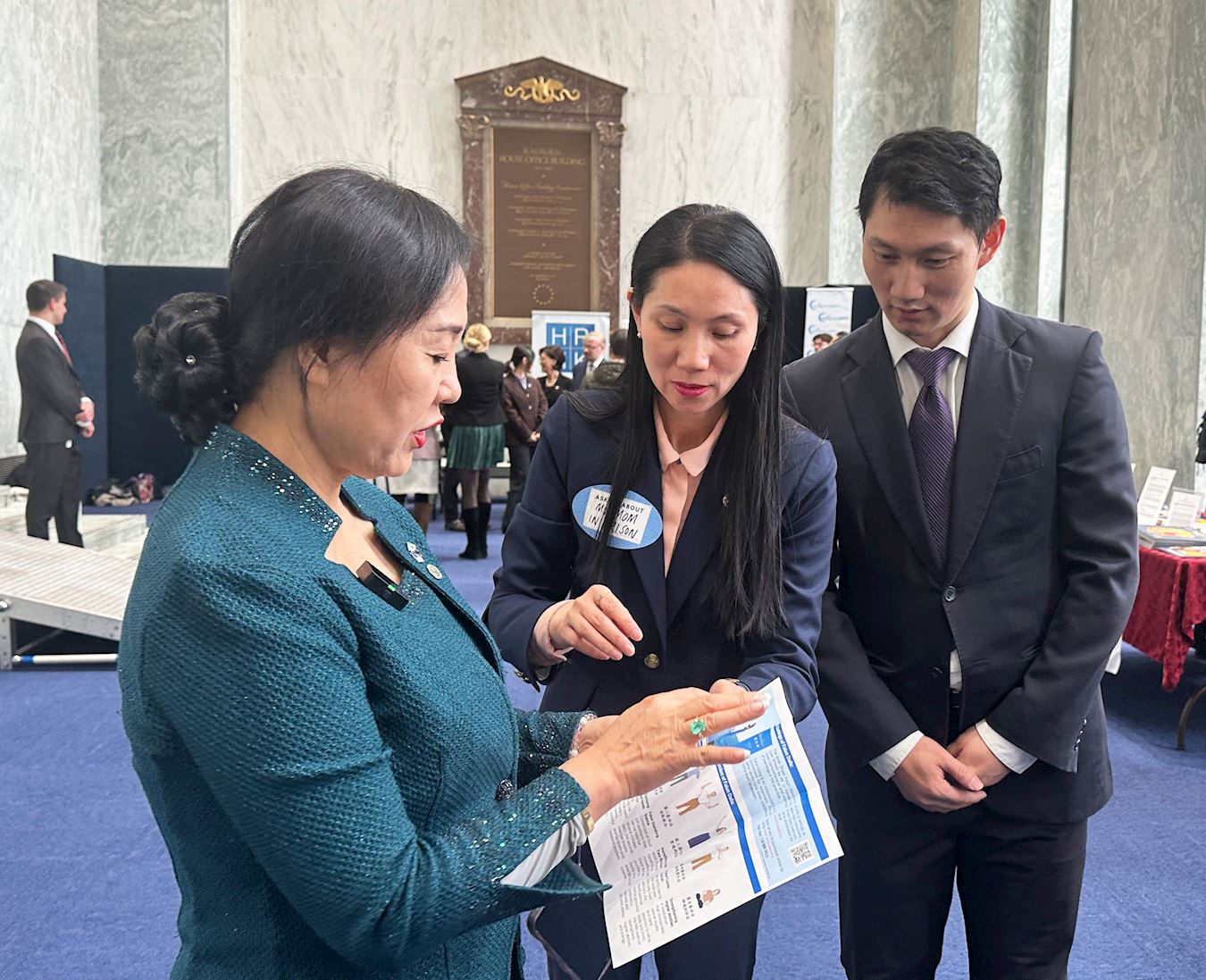 '图3:神韵艺术团前领舞演员王旋和姐姐王珊珊向一位参观者讲述法轮功受中共迫害的真相。'