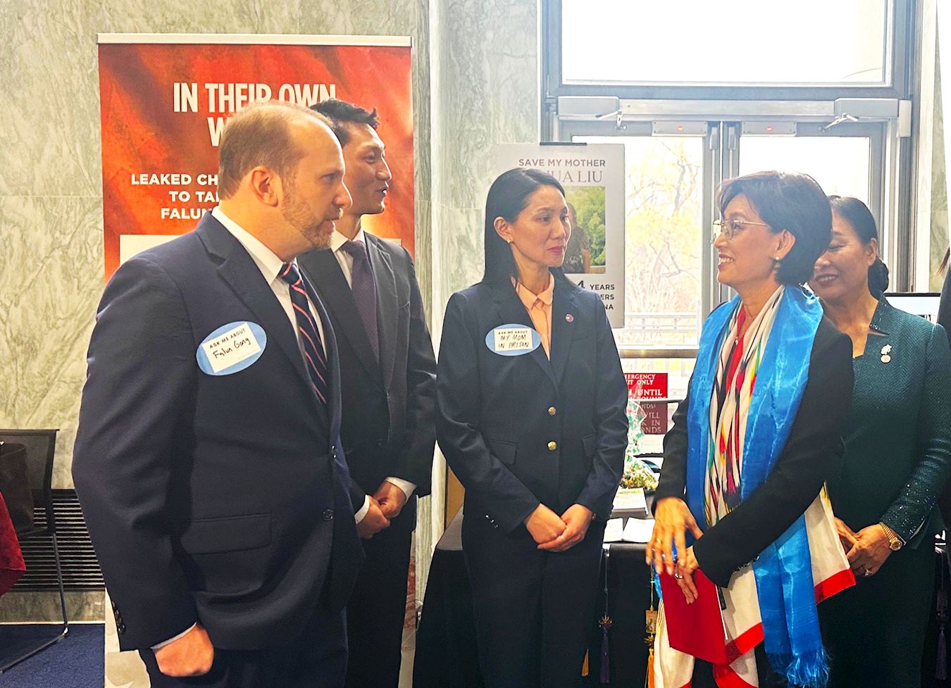 '图4:美国国会议员金映玉(右二)在法轮功展位前与学员交谈。'