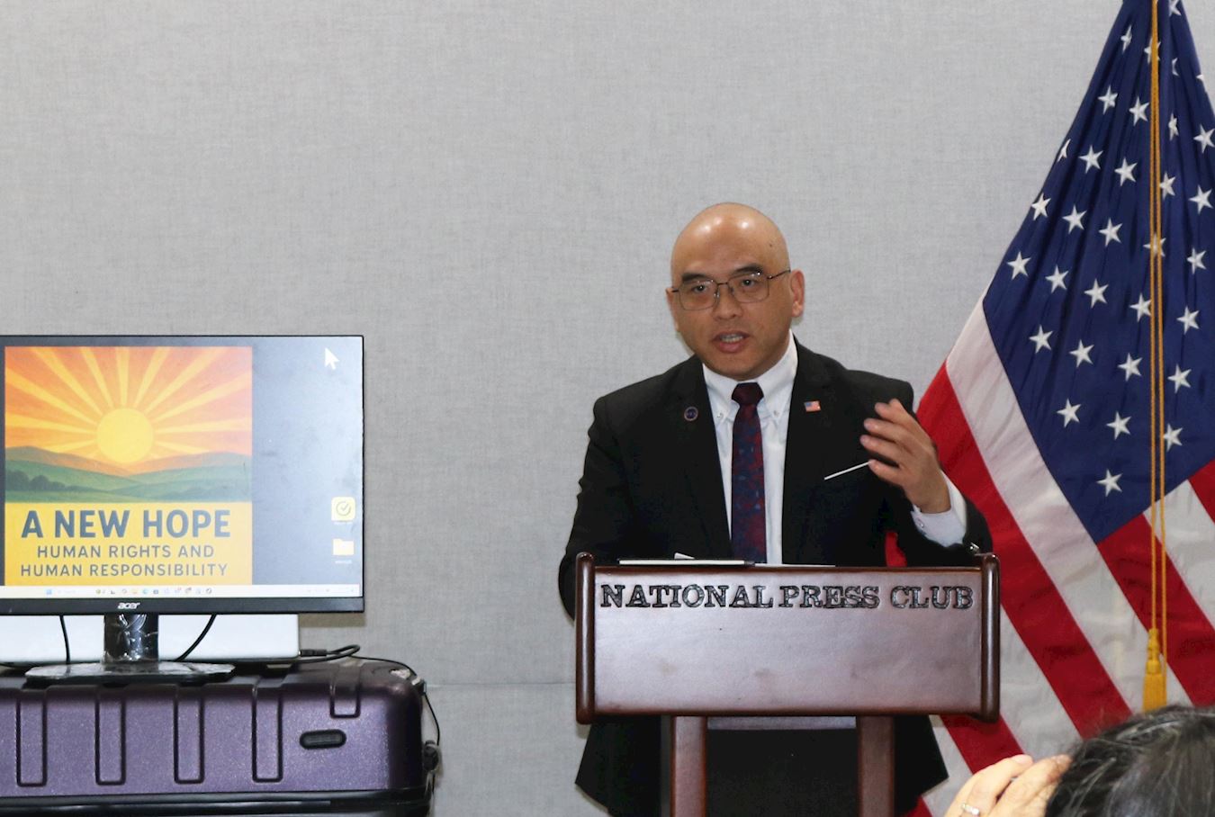 '图6:二零二五年十二月十日,在美国国家记者俱乐部举行的国际人权日新闻发布会上,法轮功学员林晓旭揭露中共迫害法轮功。'