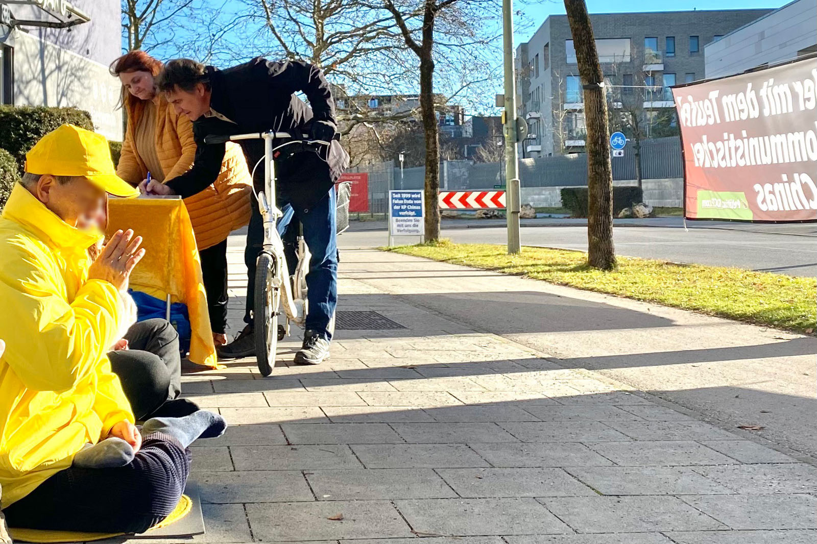 图2:路人在慕尼黑中领馆前签名声援法轮功学员反迫害。