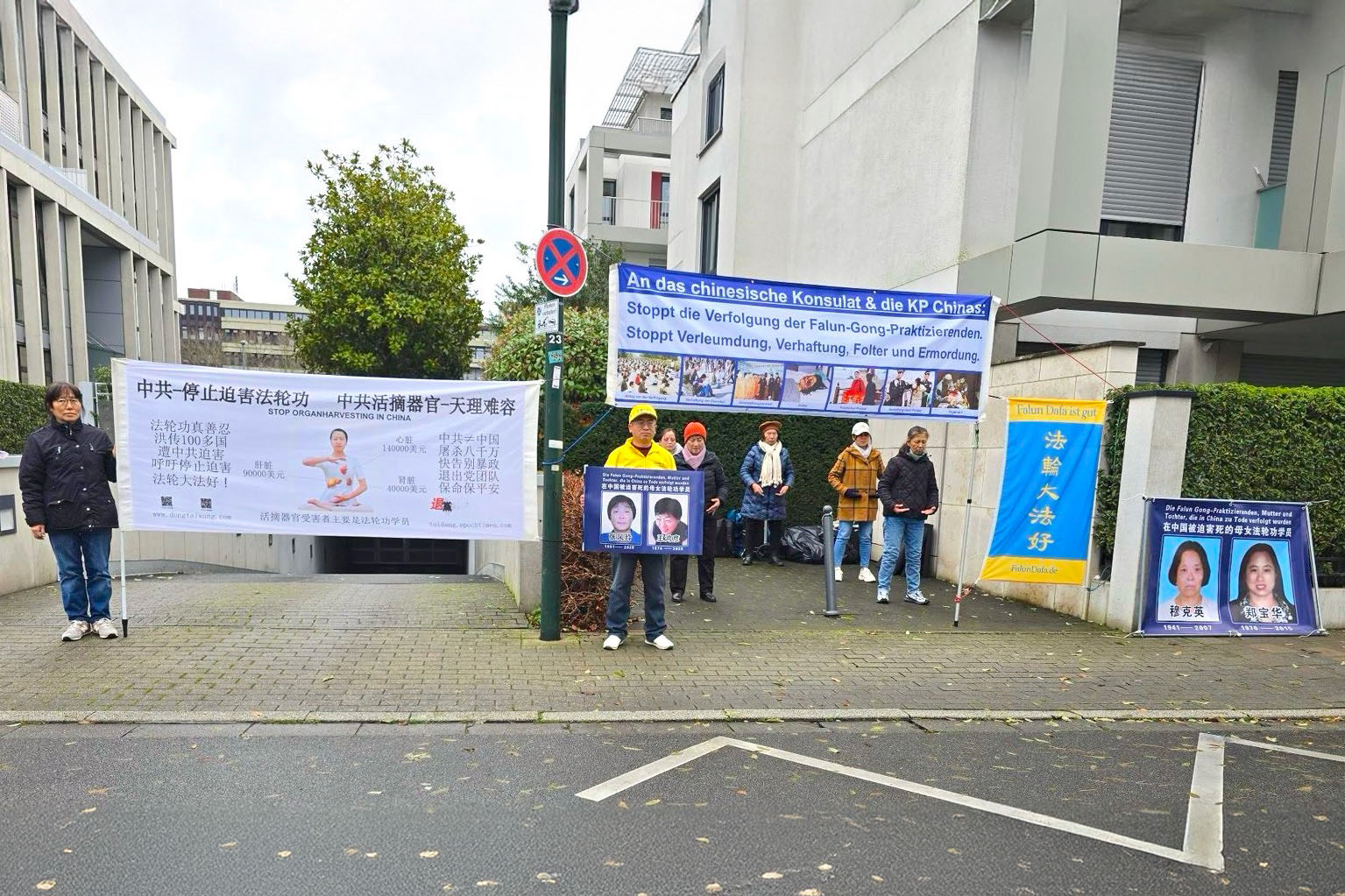 图3:二零二五年十二月十日,法轮功学员在德国西部杜塞尔多夫中领馆前举办活动。图中学员手捧着被中共迫害致死的法轮功学员、亲人的照片。