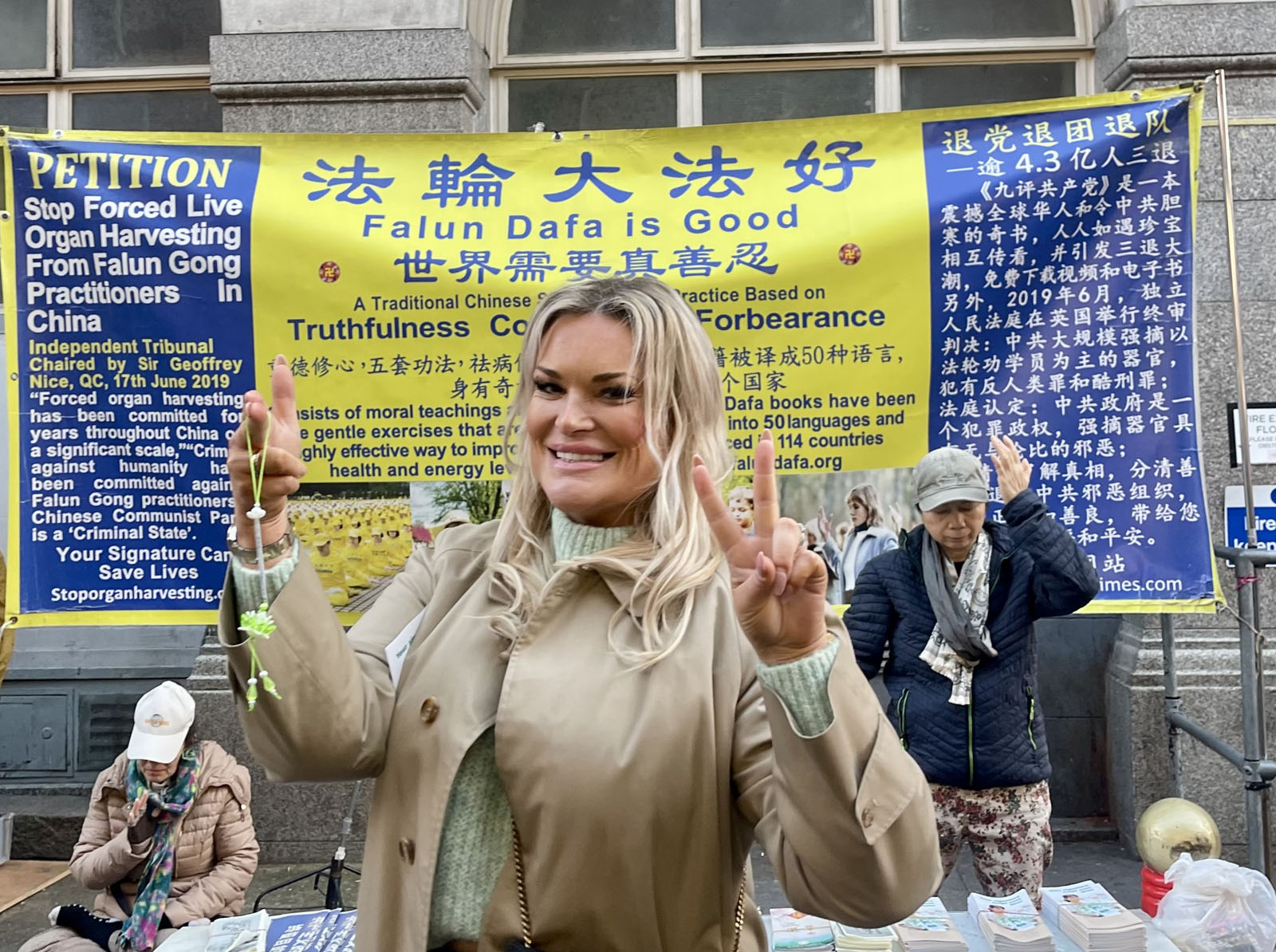 图4:来自英格兰的企业主瑞秋·伍德女士手举莲花表示支持法轮功正义反迫害