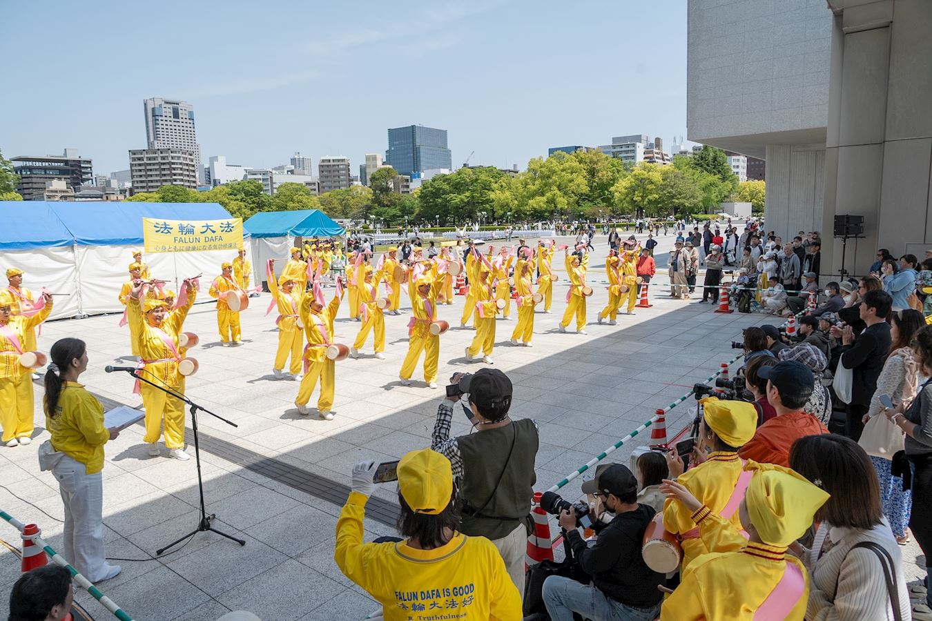 '图2:二零二五年五月三日,法轮功学员参加广岛鲜花节,在舞台表演腰鼓舞。。'