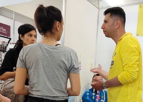 '图12~13:学员们分发法轮功真相资料,并回答民众提出的问题。'
