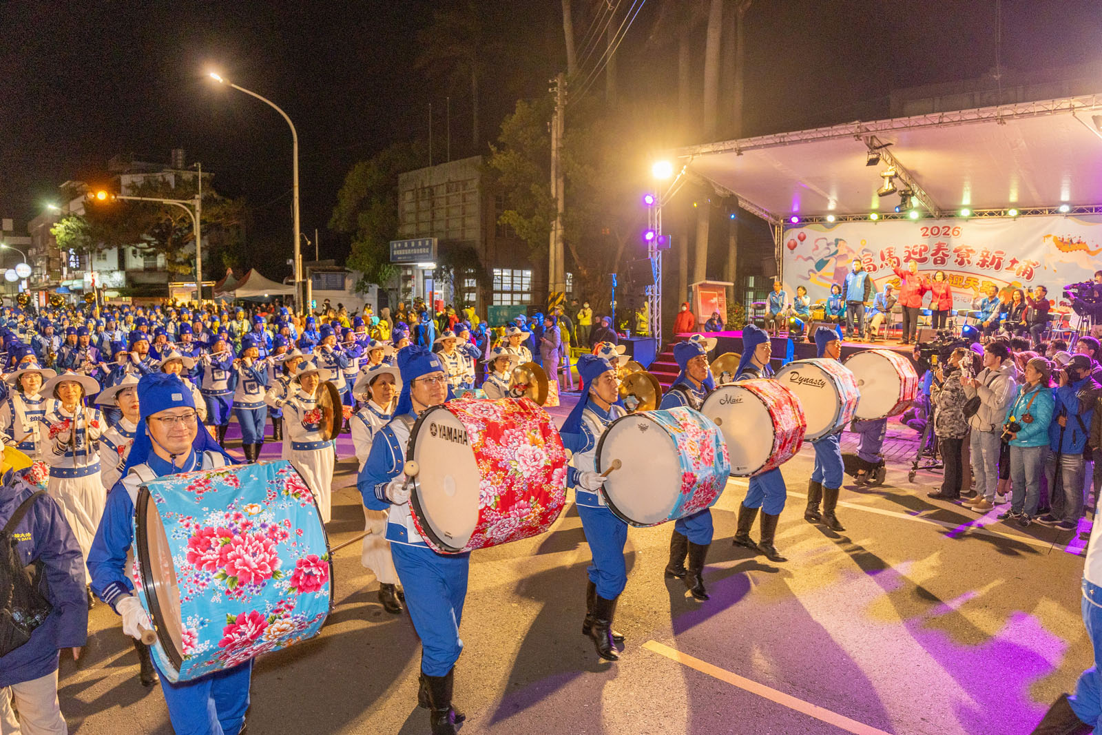 图2:天国乐团经过主舞台,阵容庞大、气势磅礴,台上新埔镇长陈英楼挥手致意。