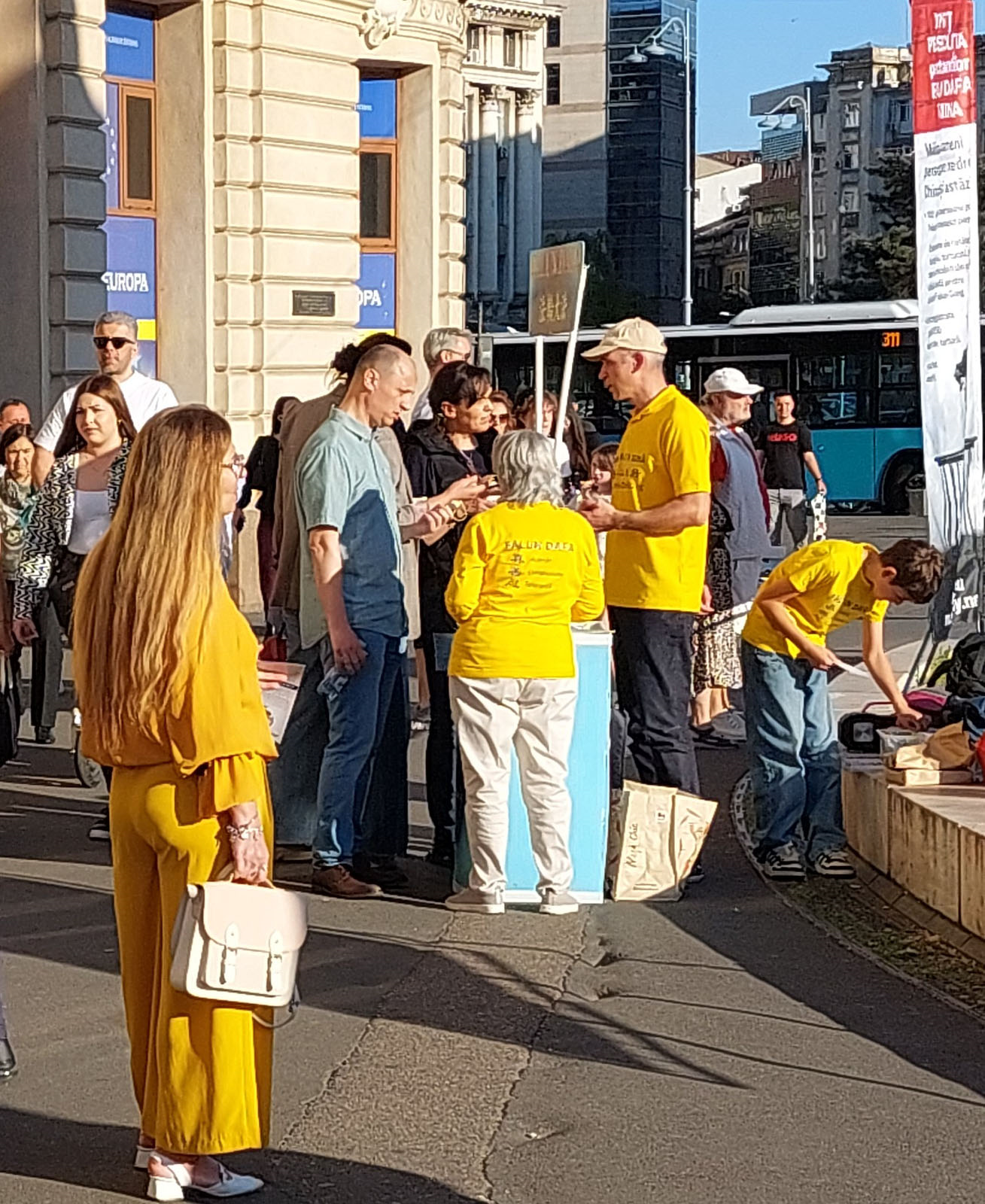 图3：二零二六年五月十五日，在布加勒斯特胜利大道，学员向路人发放资料，介绍法轮大法，并讲述中共迫害法轮大法的真相。（明慧网）