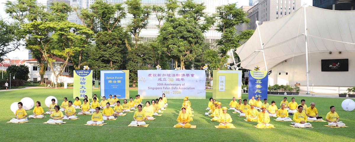 '图2~3:二零二六年七月二十一日,新加坡部分法轮功学员在芳林公园举办纪念李洪志师父莅临新加坡讲法暨法轮佛学会成立30周年庆典。图为法轮功学员在集体炼功。(明慧网)'