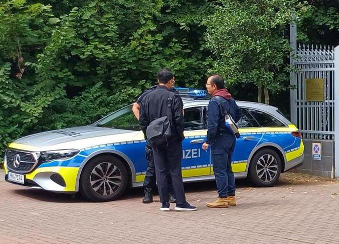 图13:中共领馆工作人员多次与德国警方交涉,试图阻止法轮功学员的抗议活动。(明慧网)