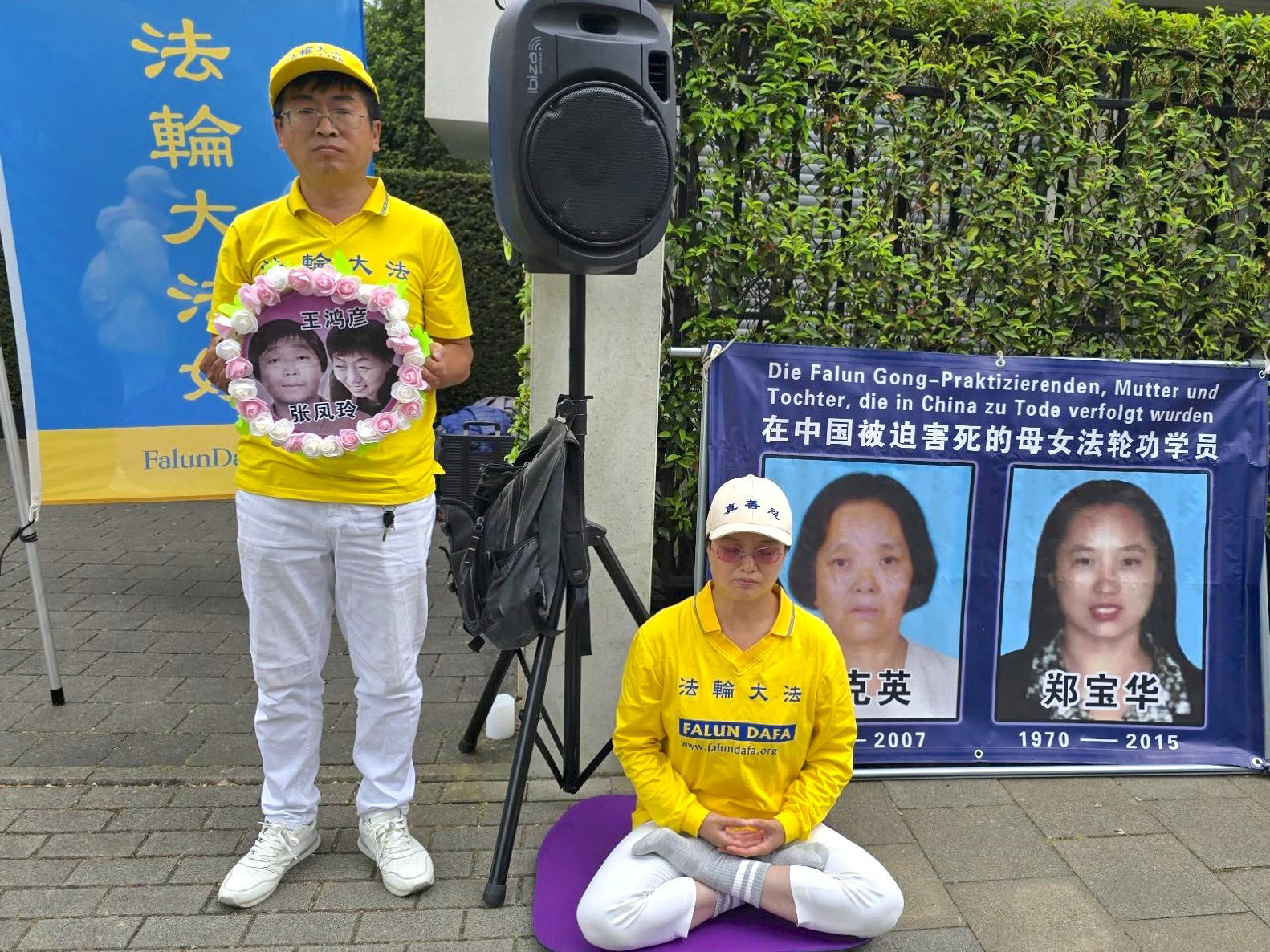 图16:法轮功学员手持受因修炼法轮功遭受中共迫害致死的亲人照片。(明慧网)
