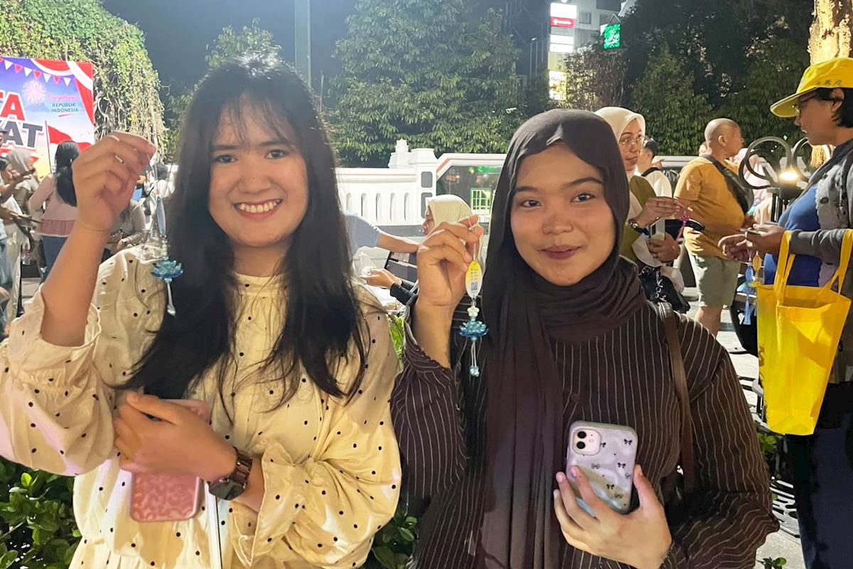 '图19:八月十六日傍晚,雪莉和安妮莎认真观看法轮大法游行。(明慧网)'