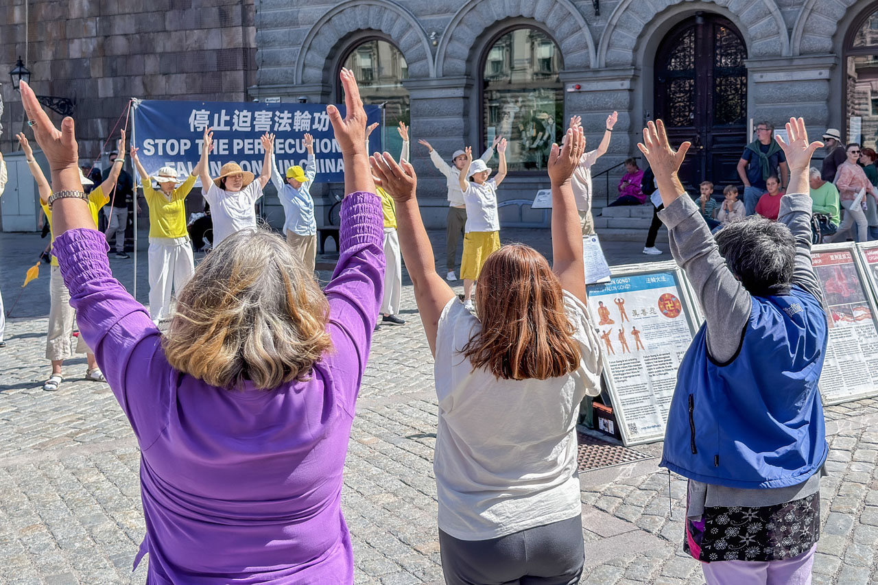 图9:许多人明白真相后对法轮功感兴趣,并当场体验炼功动作,感到能量很强。
